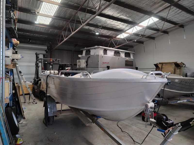 Aluminium boat with metal rails and fittings inside a workshop