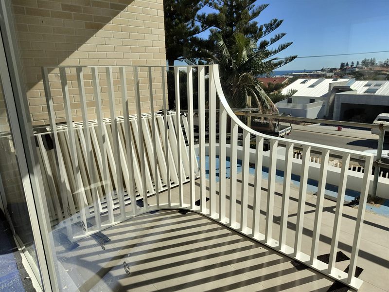 White vertical-bar railing following a curved balcony edge
