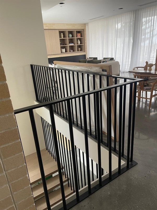 Black vertical-bar balustrade around an indoor staircase