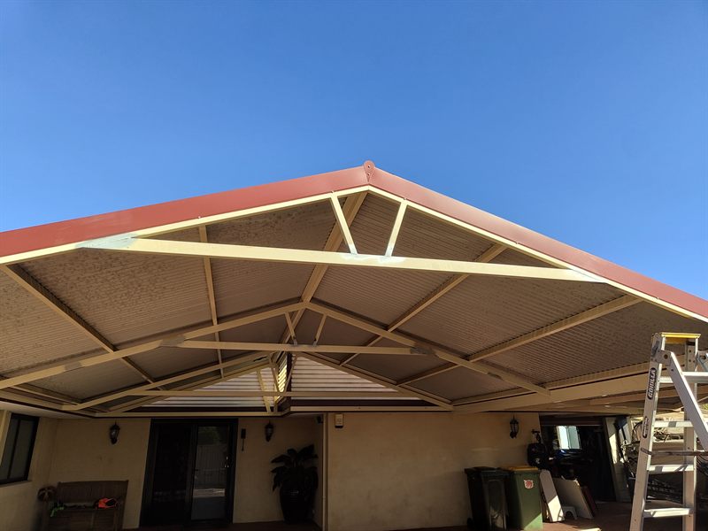 Painted steel framework supporting a pitched patio roof