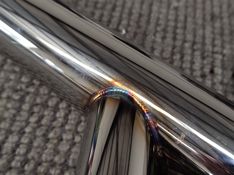 Close-up of a welded joint between polished round metal tubes