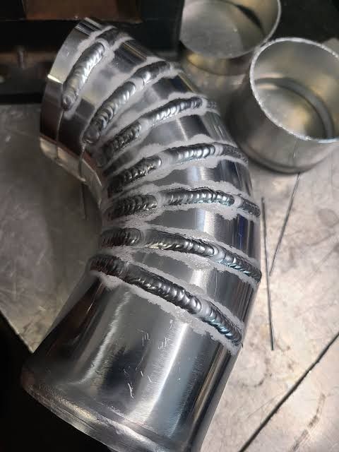 Curved pipe made from several welded metal segments