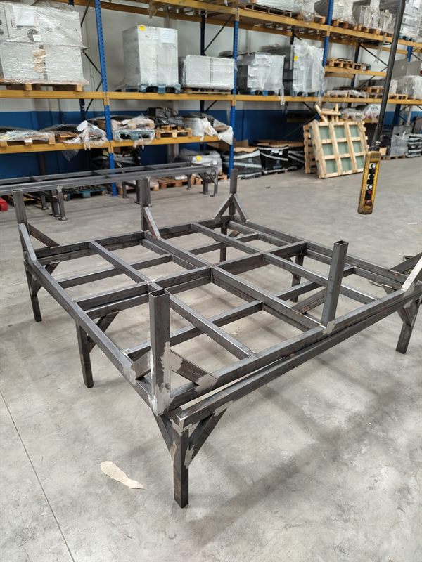 Several welded rectangular steel frames arranged in a workshop
