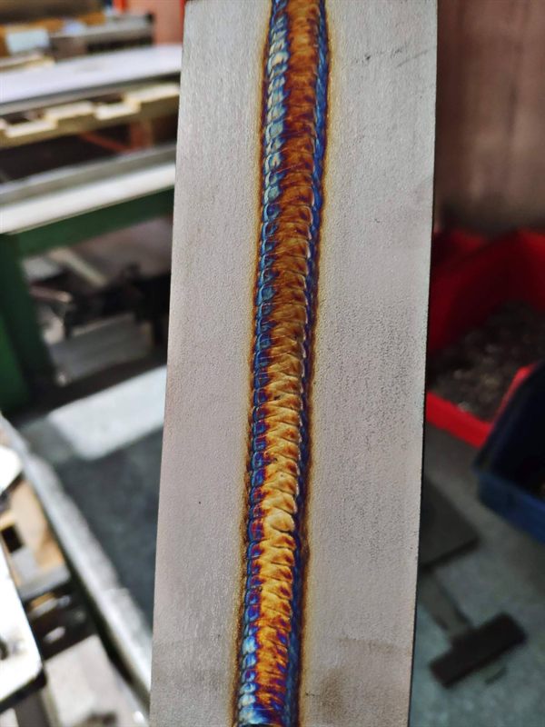 Vertical weld bead with blue and gold heat colours